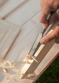 Un ciseau à bois qui rase les morceaux d'un bloc de bois.
