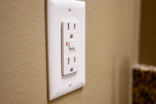 Los interruptores de circuito por fallo a tierra pueden ser disyuntores en el panel de disyuntores o instalarse directamente en los enchufes. El botón de prueba simula un fallo y el botón de reinicio vuelve a conectar el disyuntor.