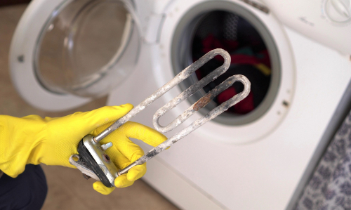 Un vieil élément de chauffage de l'eau d'une machine à laver qui doit être remplacé en raison de l'accumulation de calcium.
