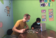 Paulus playing jigsaw with a child.