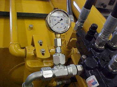 Een hydraulische manometer die aan het hydraulische systeem van een kloofmachine is bevestigd.