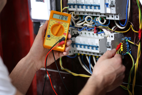 Using a multimeter to measure the voltage in a service panel