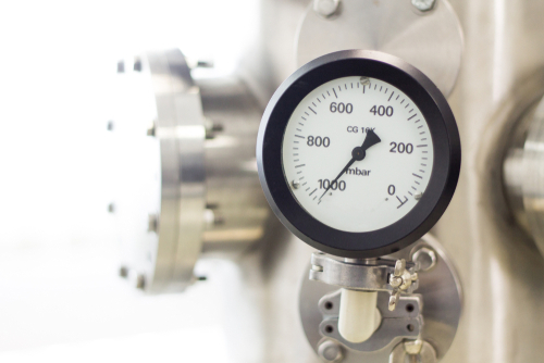 A vacuum pressure gauge on a vacuum chamber in a laboratory.
